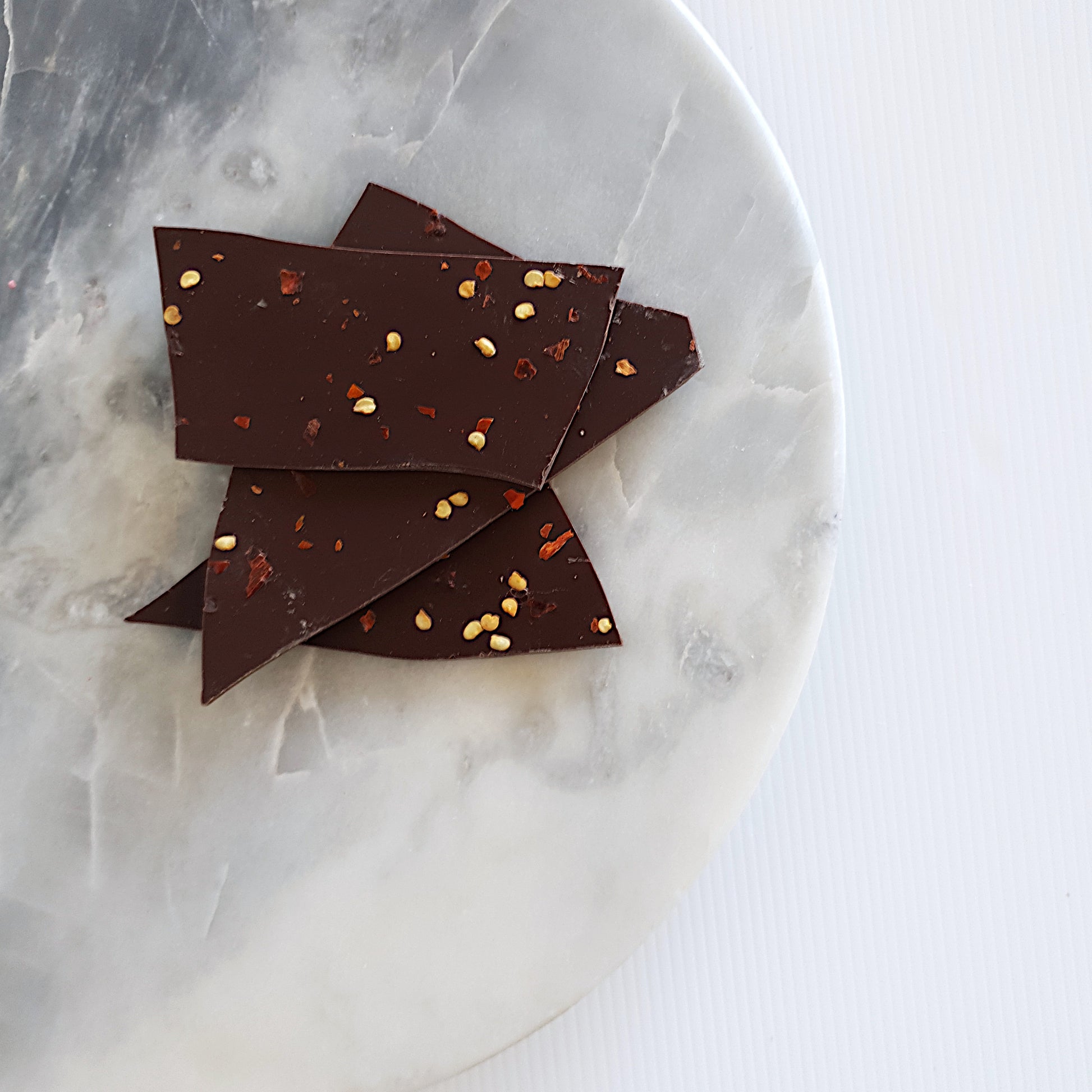 Dried chilli flakes scattered on Callebaut Belgian 54% dark chocolate bark. Available in 100g for local delivery and shipping Australia wide